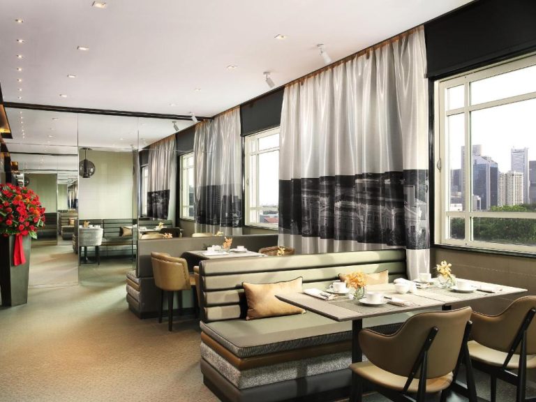 Elegante restaurante con vistas al skyline de Singapur en Rendezvous Hotel Singapore by Far East Hospitality