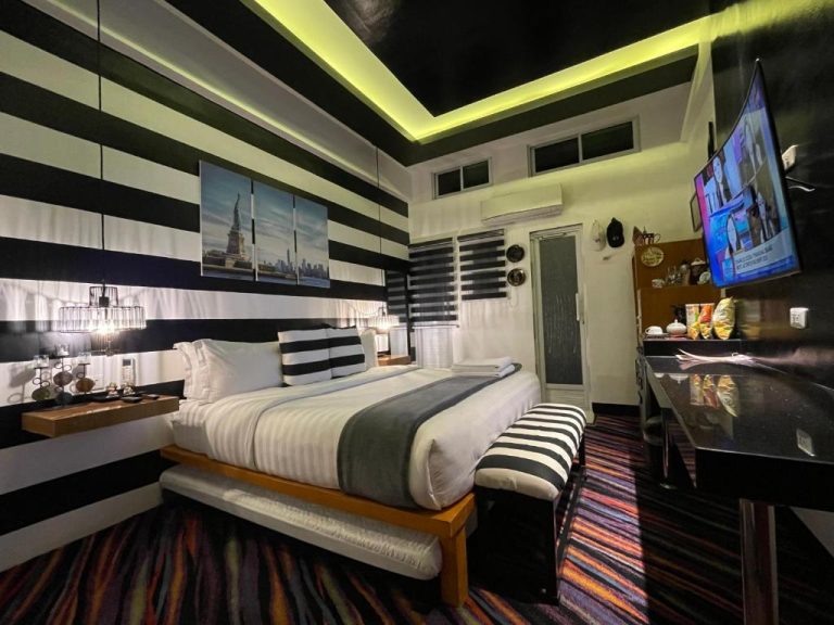 Habitación doble con decoración en rayas blancas y negras en Italy Condotel Darasa con TV y cama king