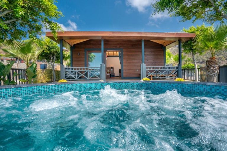 Jacuzzi exterior con burbujeo activo frente a bungalow de madera en Porto Amore Club Hotel