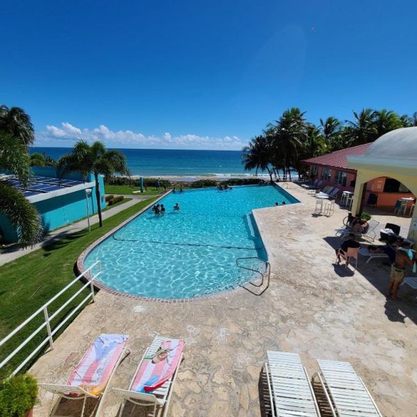 Piscina exterior con vista al mar y tumbonas del Parador Maunacaribe en Maunabo, Puerto Rico
