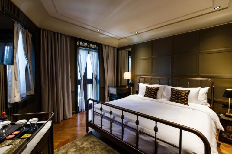 Habitación doble de lujo con cama de hierro forjado y decoración elegante en Hotel Verdigris