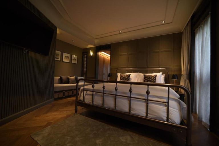 Habitación de lujo con cama de hierro forjado y suelo de parqué en Hotel Verdigris