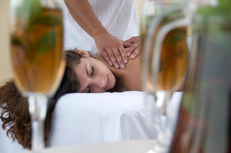 Tratamiento de masaje relajante en el spa del hotel Aegean Houses con copa de champán