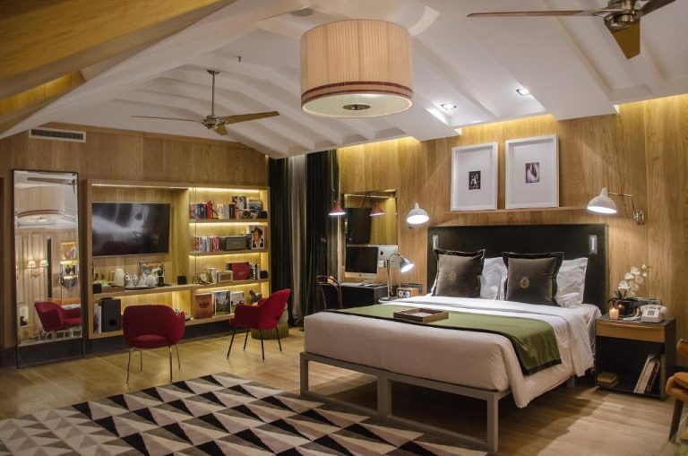 Suite de lujo con cama doble, paredes de madera y decoración elegante en Browns Central Hotel