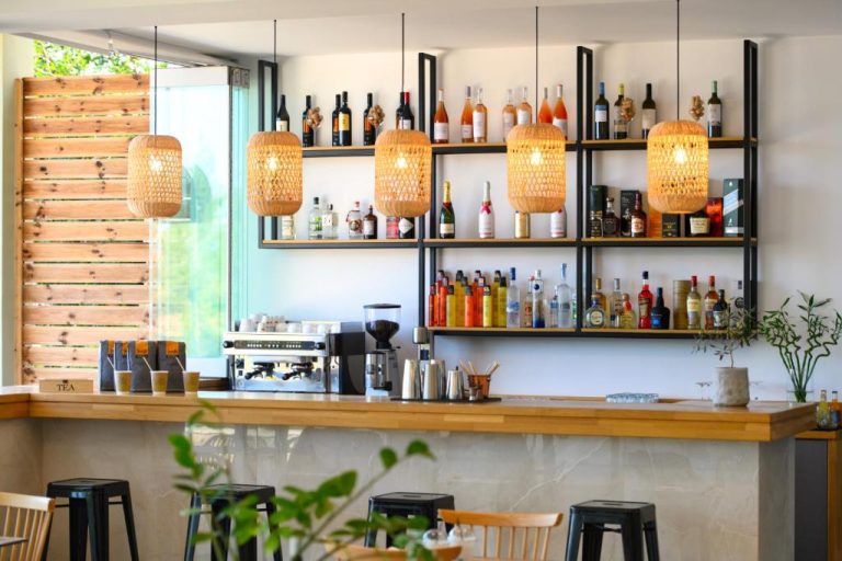 Bar y coctelería del Eleals Boutique Hotel con estantería de licores y lámparas de ratán