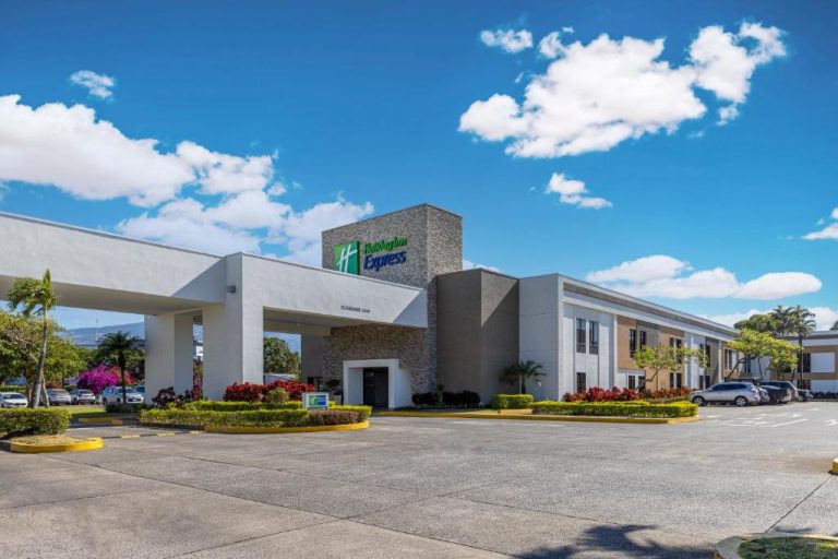 Fachada exterior y entrada principal del Holiday Inn Express San José Airport Costa Rica con amplio estacionamiento