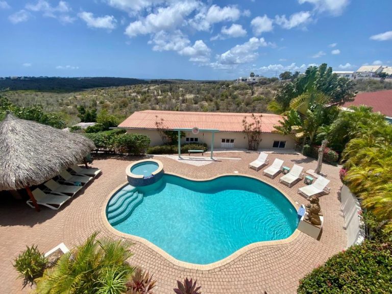 Piscina exterior con jacuzzi y tumbonas del Home Sweet Home Jan Thiel Curaçao con vistas al paisaje