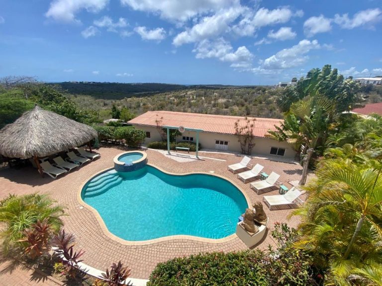Piscina exterior con jacuzzi y tumbonas del Home Sweet Home Jan Thiel en Curaçao con vistas al mar