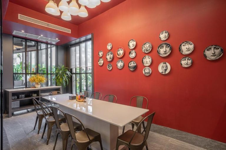 Sala de comedor con pared roja y platos decorativos en el I Pavilion Hotel Phuket