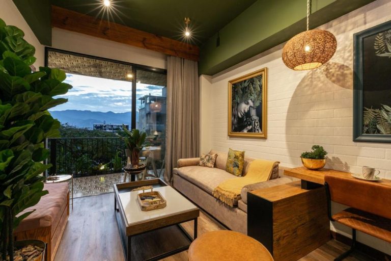 Salón moderno con sofá, decoración tropical y vistas a la montaña en Celestino Boutique Hotel & Spa