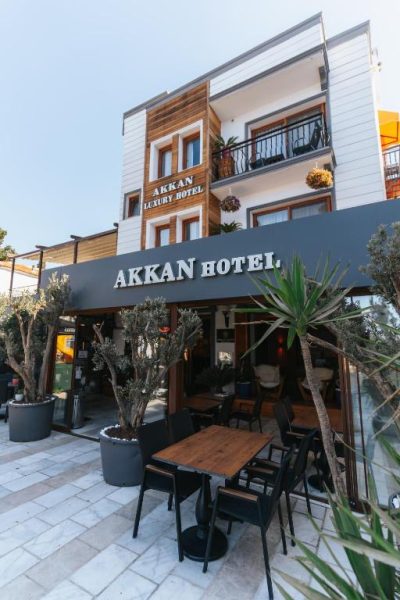 Terraza exterior con mesas y sillas del Akkan Luxury Hotel con fachada moderna de madera