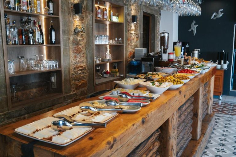 Amplio buffet de desayuno con variedad de platos y barra de madera rústica en el Akkan Hotel