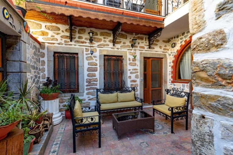 Terraza exterior con mobiliario de forja del Akkan Hotel, rodeada de muros de piedra tradicional