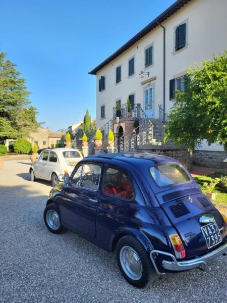 Dos Fiat 500 clásicos aparcados frente a la elegante villa toscana del Cortona Resort & Spa