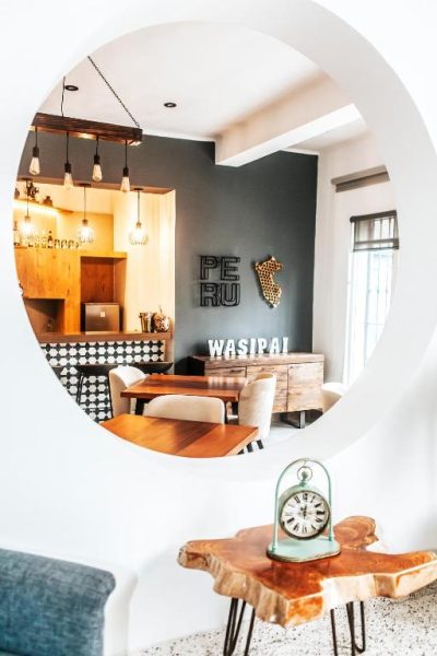 Salón comedor con decoración peruana y espejo circular en WasiPai Boutique Hotel