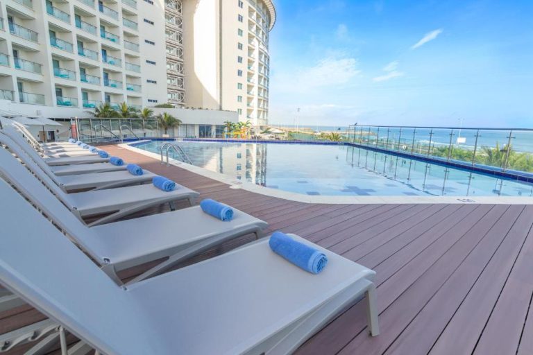 Piscina exterior con tumbonas y vista al mar del Hotel GHL Corales de Indias en Cartagena