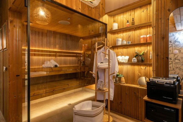 Sauna finlandesa de madera con zona de descanso y vestuario en Celestino Boutique Hotel & Spa