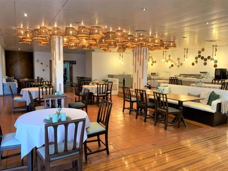 Restaurante interior del Quinta da Penha de Franca con mesas blancas y lámparas de mimbre en el techo