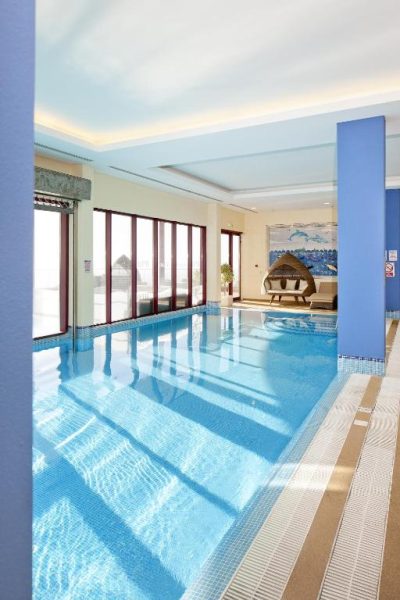 Piscina interior climatizada con luz natural del Village Cabo Girao, zona de relax con tumbonas