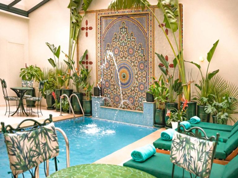 Piscina interior con fuente y mosaico árabe del Hotel Safia, rodeada de plantas tropicales y tumbonas