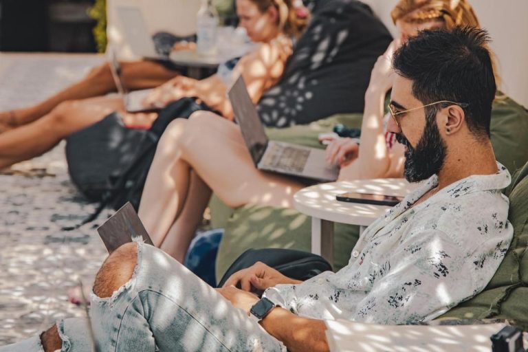 Huéspedes trabajando con laptops en la terraza exterior del hotel Layla Tulum Adults Only