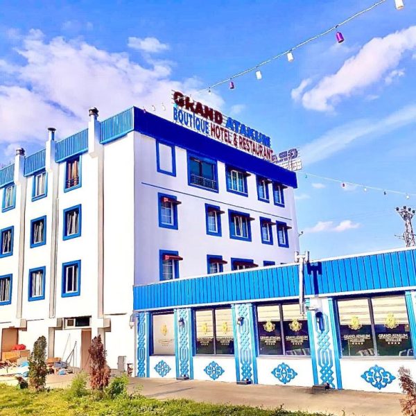 Fachada exterior del Grand Kum Boutique Hotel con decoración azul y blanca y restaurante integrado