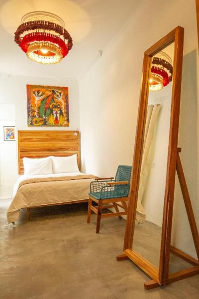 Habitación doble con espejo de pie y decoración artística en Hotel NaNa Vida CDMX