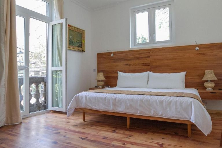Habitación doble con cama king size y cabecero de madera en Hotel NaNa Vida CDMX