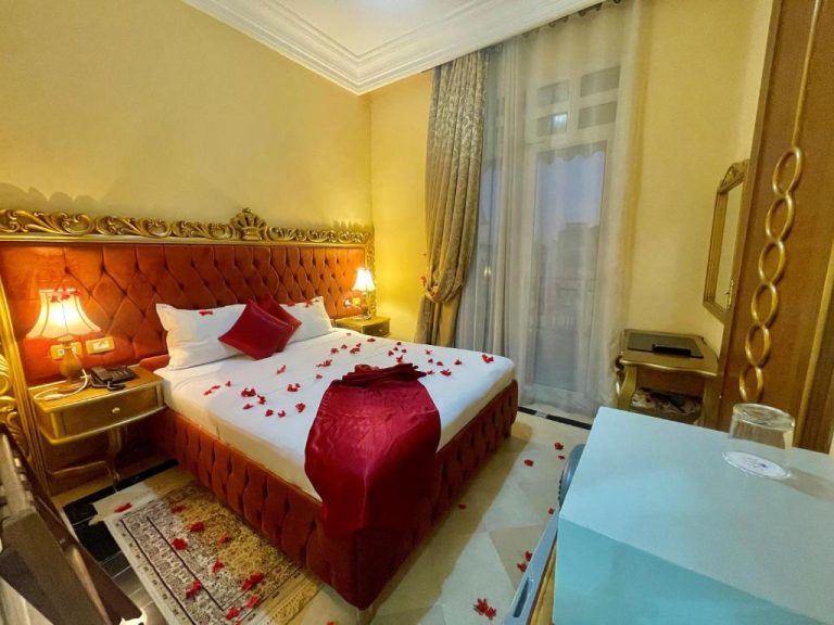 Habitación romántica con pétalos de rosas rojas en la cama del Hotel Royal Victoria Ex British Embassy
