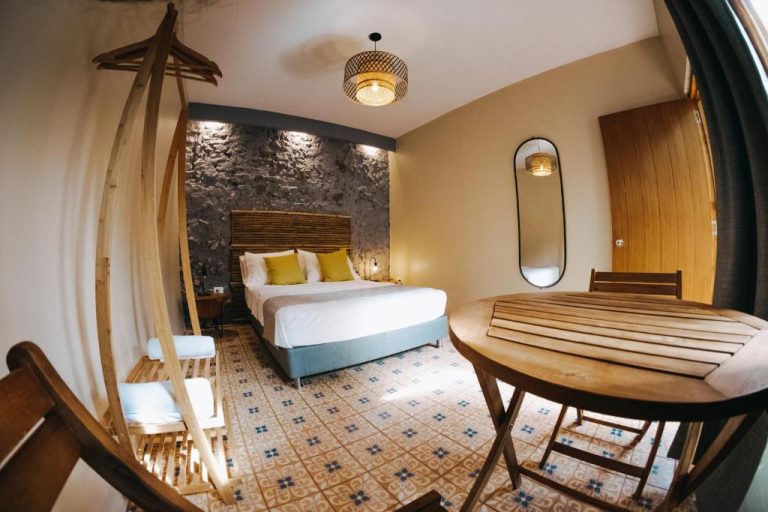 Habitación doble con cama matrimonial, suelo hidráulico y decoración rústica en Viajero Cartagena Centro Hostel