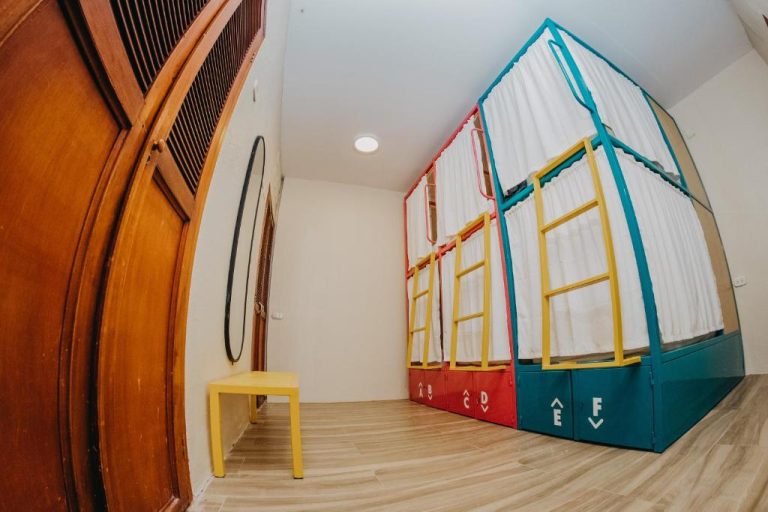Literas compartidas con cortinas de privacidad y taquillas de colores en Viajero Cartagena Centro Hostel