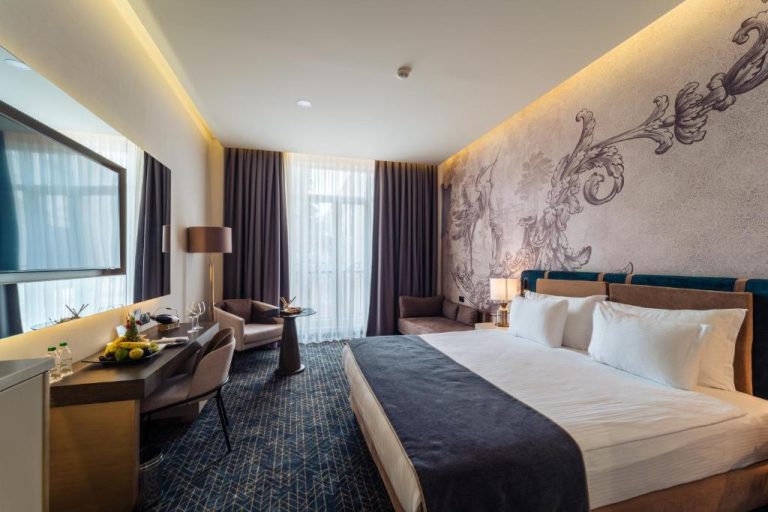 Habitación deluxe con cama king size y mural artístico en IC Hotels Airport