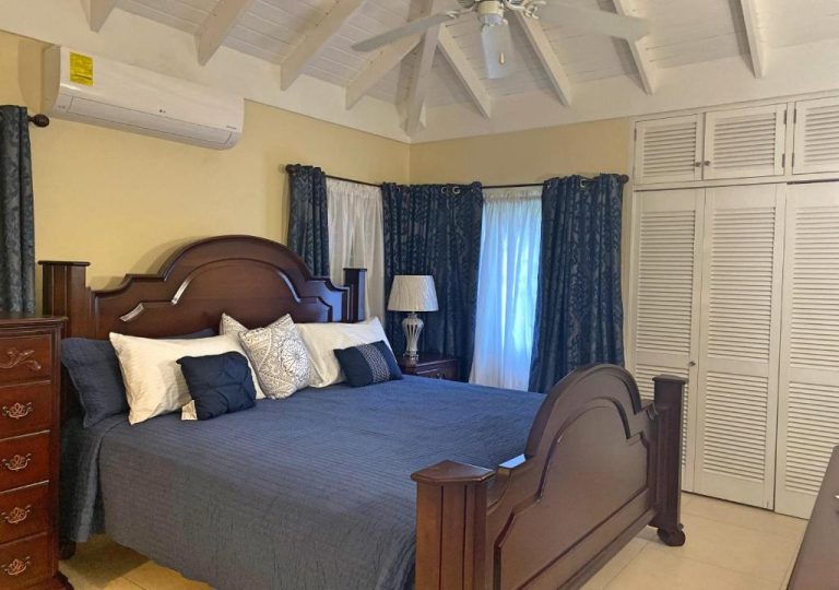 Habitación principal con cama king size y decoración azul en Jamnick Vacation Rentals, Jamaica