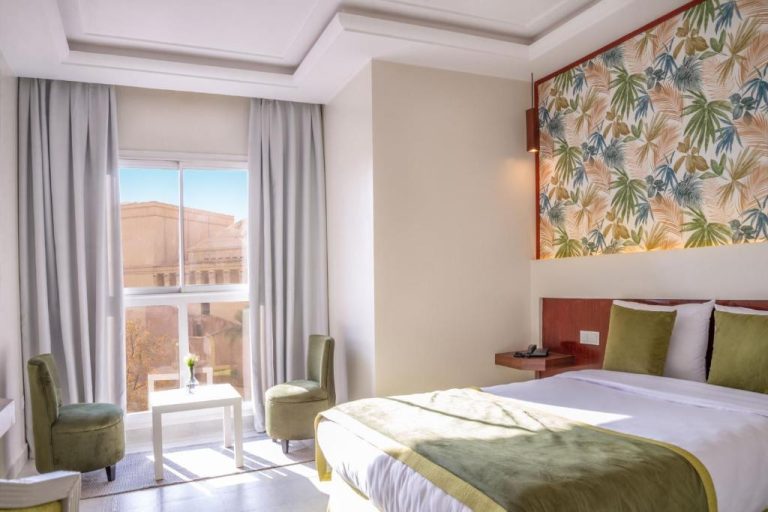 Habitación doble con cabecero tropical y luz natural en Hotel Safia Marrakech