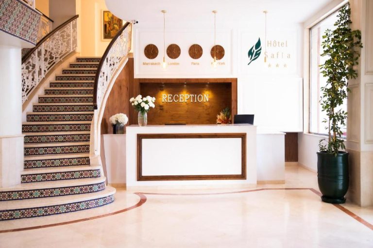 Recepción principal del Hotel Safia con elegante escalera de mosaicos y relojes internacionales