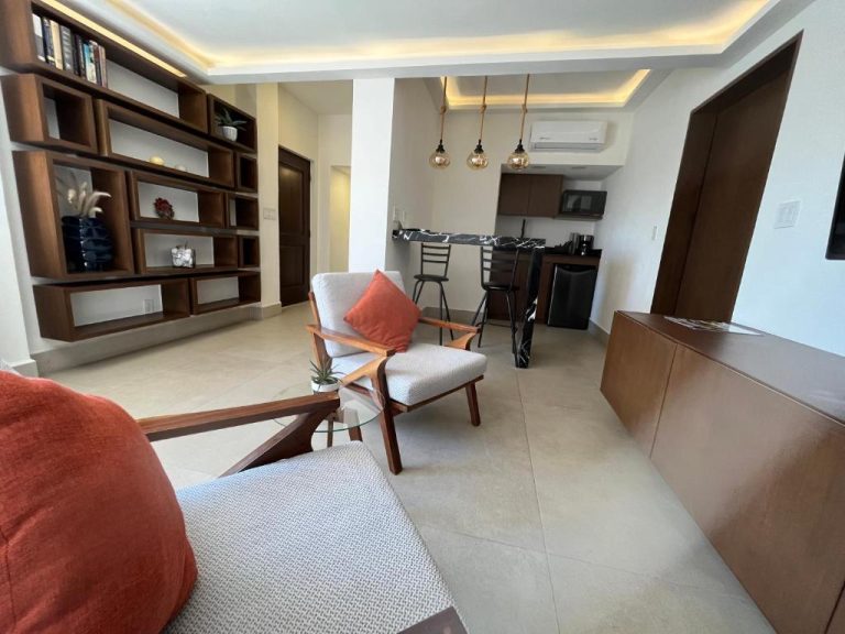 Sala de estar moderna con sillones de madera y cocina integrada en Marisol Hotel Boutique