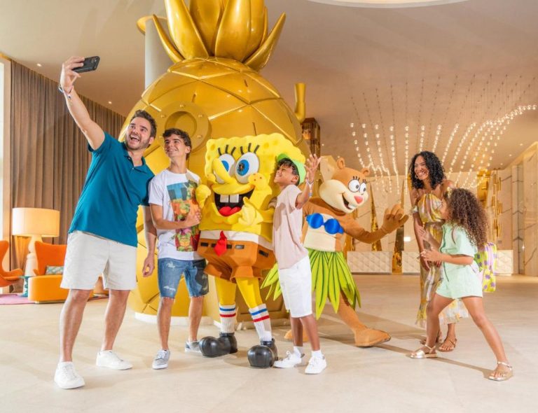 Familia posando con SpongeBob y Sandy en el lobby del Nickelodeon Hotels & Resorts Riviera Maya