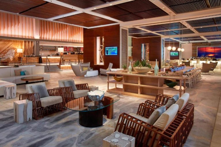 Elegante lobby lounge del Aruba Marriott Resort con mobiliario de madera y zona de bar iluminada