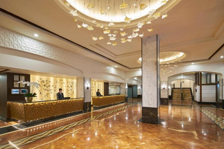 Lujoso lobby con recepción dorada y araña de cristal del Orchard Rendezvous Hotel by Far East Hospitality