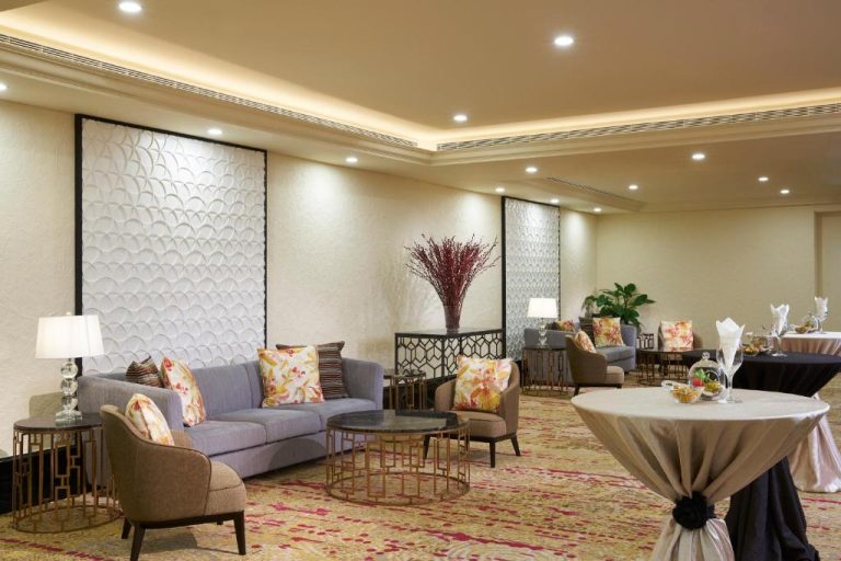 Elegante salón de eventos con sofás y decoración floral en Orchard Rendezvous Hotel by Far East Hospitality