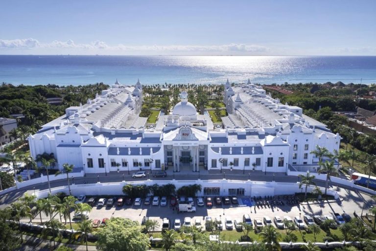 Vista aérea de la imponente fachada blanca del Riu Palace Riviera Maya frente al mar Caribe