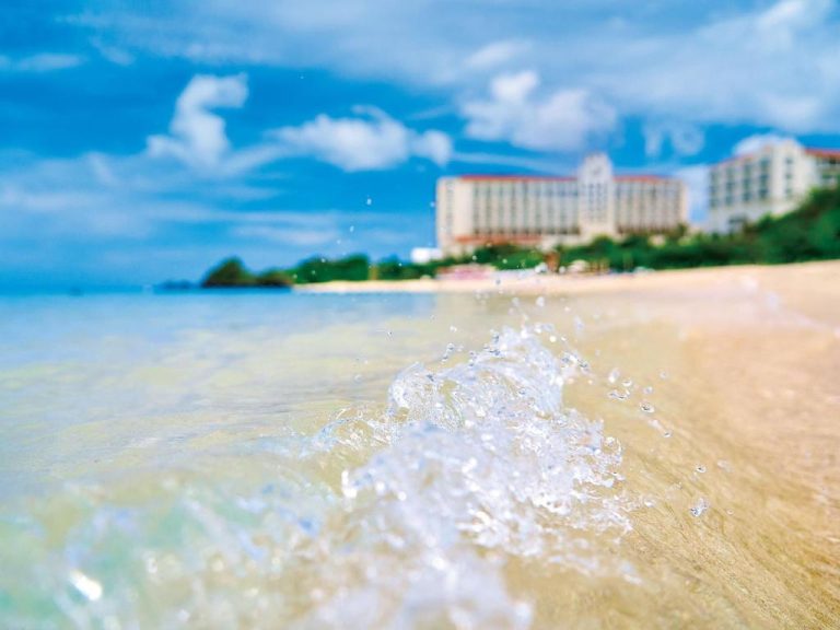 Playa de arena blanca con olas cristalinas frente al Hotel Nikko Alivila en Okinawa, Japón