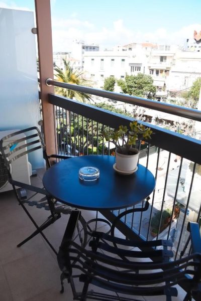Terraza con mesa y sillas azules del Adrian Hotel con vistas panorámicas a la ciudad