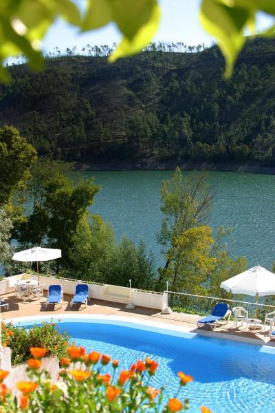 Piscina exterior con vistas al lago y montaña del Lago Azul Eco Hotel rodeada de naturaleza