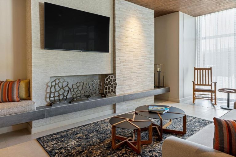 Sala de estar con chimenea moderna y TV en Fairfield by Marriott San Jose Airport Alajuela