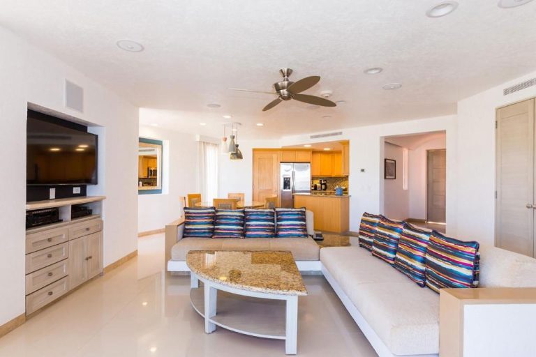 Sala de estar con sofá, TV y cocina abierta en The Westin Los Cabos Resort Villas Baja Point