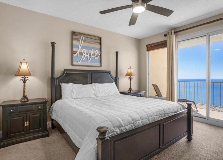 Habitación con cama king size y vista al mar desde balcón en Treasure Island 2102 Beach Front
