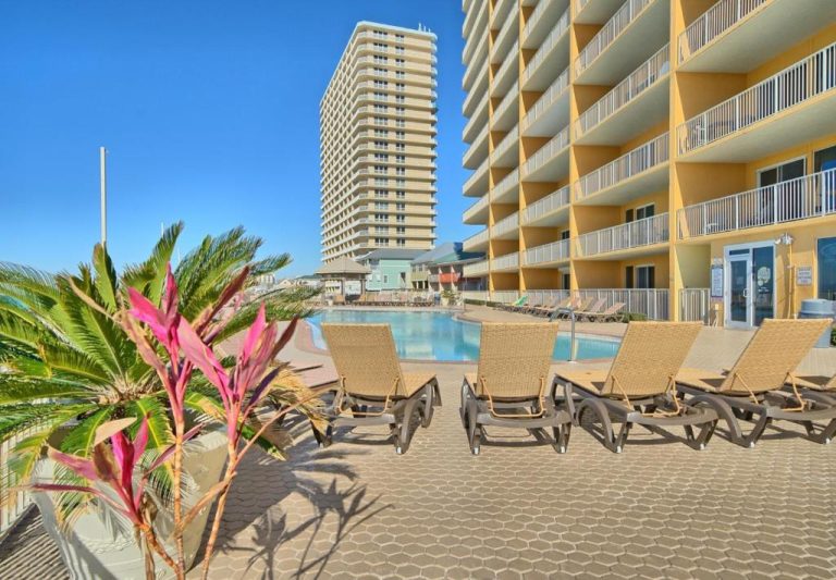 Piscina exterior con tumbonas y terraza del Treasure Island 2102 Beach Front con vistas a los edificios