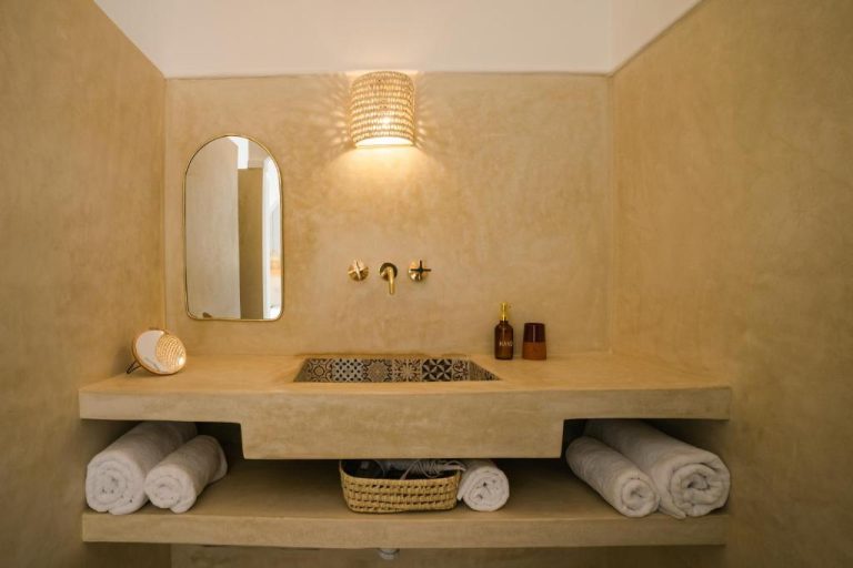 Baño con lavabo empotrado de estilo marroquí y accesorios dorados en Riad Rahal