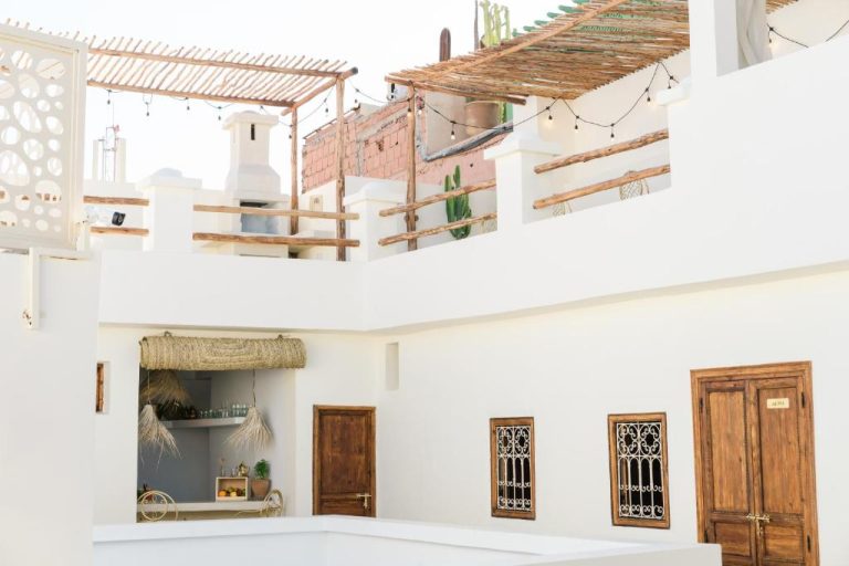 Patio interior con terraza y puertas de madera tradicionales del Riad Rahal en Marruecos